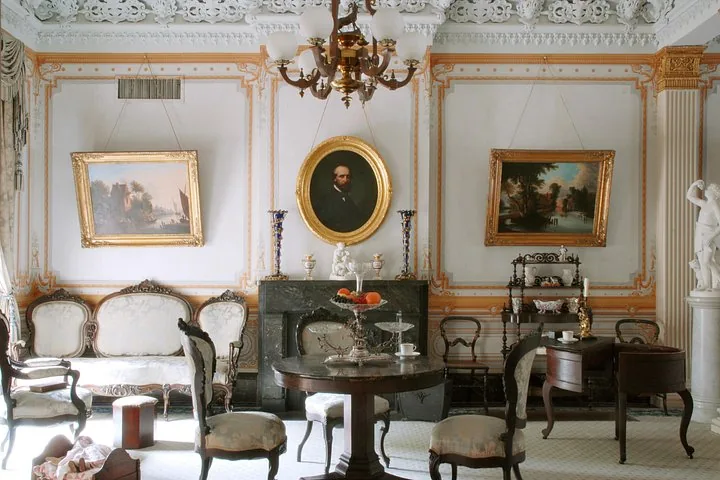 Historischer Salon mit Kamin, Porträts und antiken Möbeln