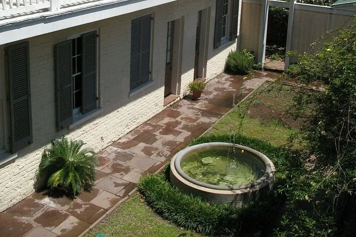 Zona del patio con suelo de piedra y una fuente de agua circular