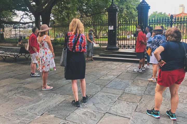 Eine Gruppe von Touristen versammelt sich im Freien um einen Guide