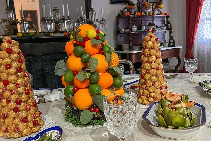 Mesa de comedor preparada con elaborados centros de mesa hechos de frutas y frutos secos